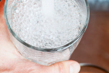 Point of view shot of a man pouring a glass of fresh water from a kitchen faucet