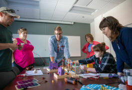 Teachers sitting in circle around a microgrid deomonstration