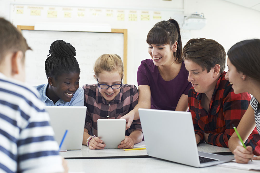 Students around laptops and tablets