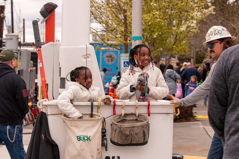 Two girls standing inside bucket of truck