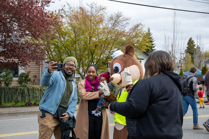 Smiling family taking selfie with mascot