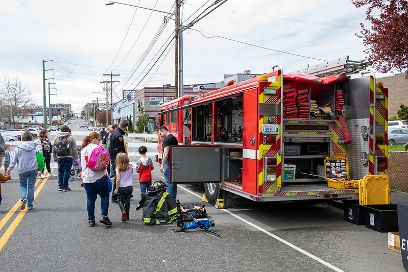 A family checks out the inside of a bright red fire engine