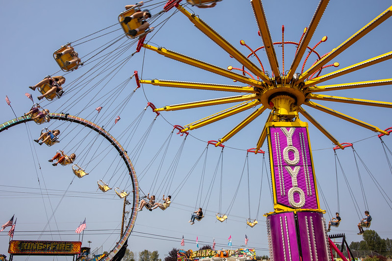 Big colorful YoYo ride swirls under a bright blue sky