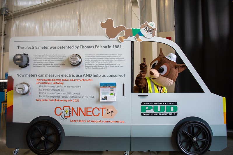 Mascot Squirrel, Zip, sits in Connect Up Display and points at image of sibling squirrel, Zap.