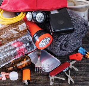 Snapshot of emergency kit items including batteries, flashlight, food and a blanket
