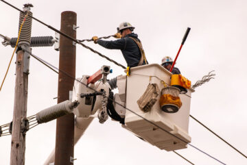 Modern linemen working to install a new pole.
