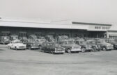 Cars and service truck parked outside PUD headquarters in the 1950s