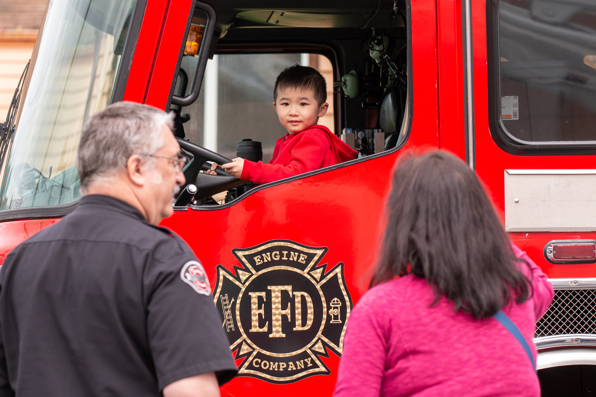 Young fireman in training has fun behind the wheel