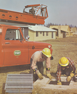 Two workers dig into an underground job while a dashing red truck waits in the background