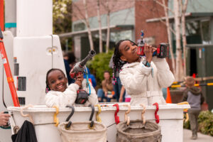 two happy children play with tools in the bucket of a line truck