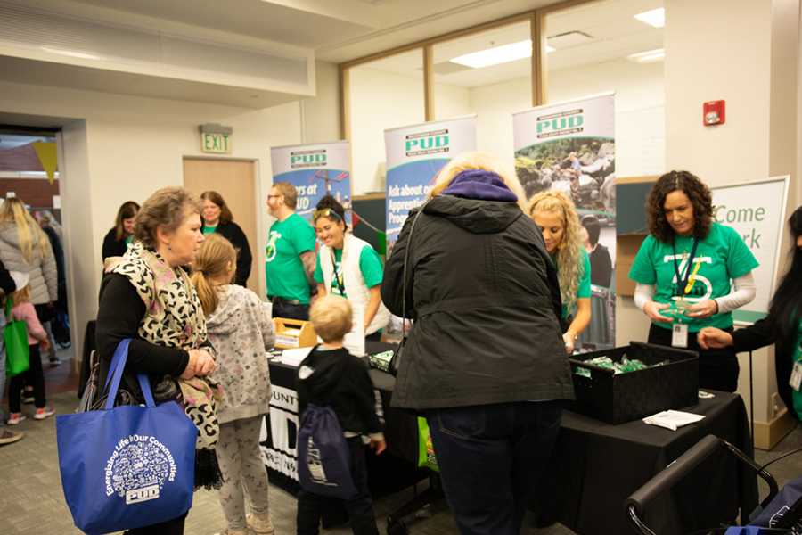 The PUD HR team chats with customers at their table at the Energy Block Party