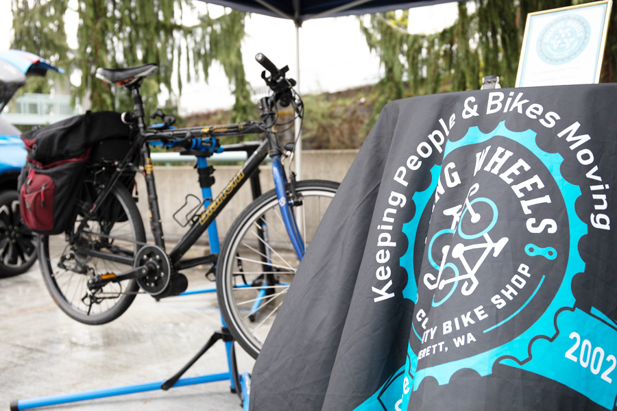 Một bức ảnh tại lều của Sharing Wheels Energy Block Party có biểu ngữ và một chiếc xe đạp