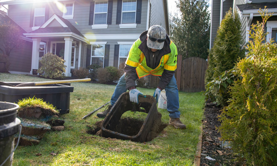 A man drops a water meter box in place