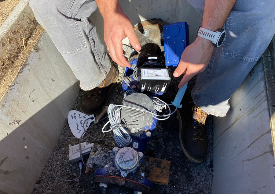Man leans over advanced water meter as he installs it