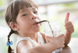 Cute little girl enjoying refreshing glass of water