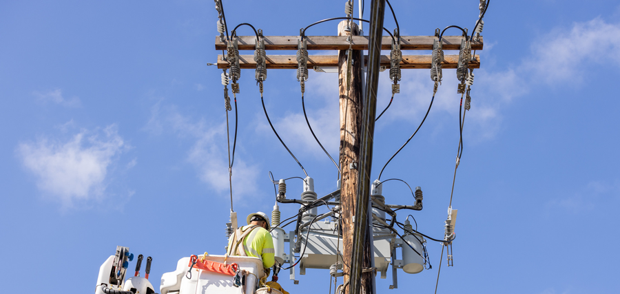 Line crew installing a three-phase recloser
