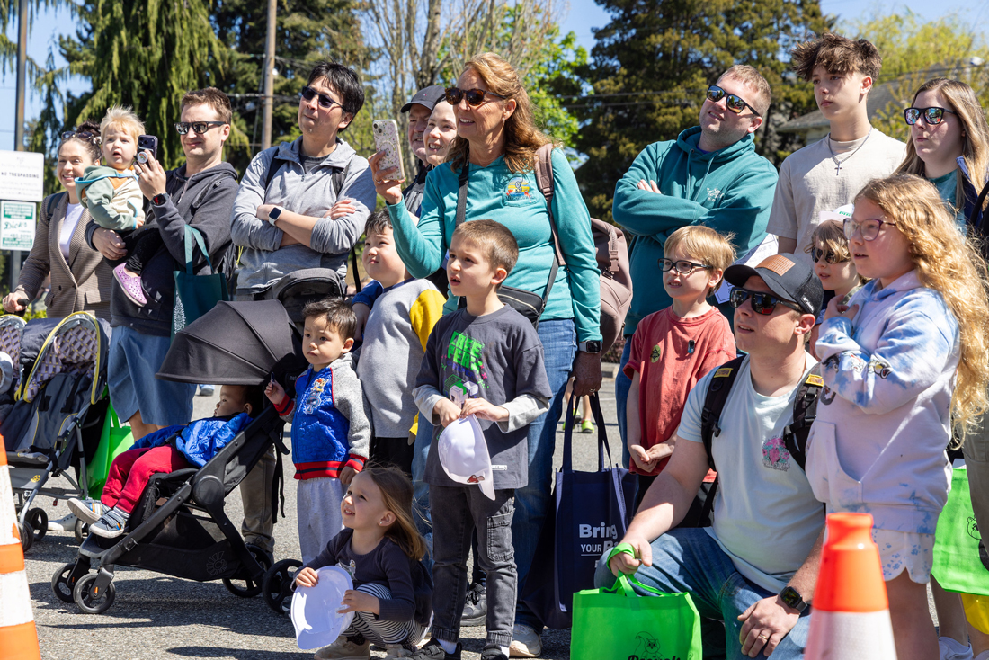一群人面带惊讶和好奇的表情观看电气安全演示，其中几个人正在拍摄。