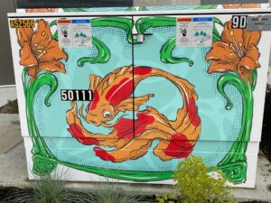 Brightly colored utility box wrap with carp with long tail and water lillies