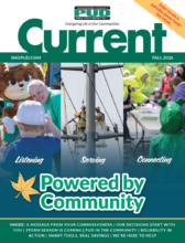 这是斯诺霍米什县公共事业区 (Snohomish County PUD) 2026 年秋季刊《Current》杂志的封面。封面包含三张以社区为主题的照片，分别展示了儿童与公共事业区吉祥物和员工互动、电力线路工人维修电气设备以及社区成员参加户外活动的场景。 